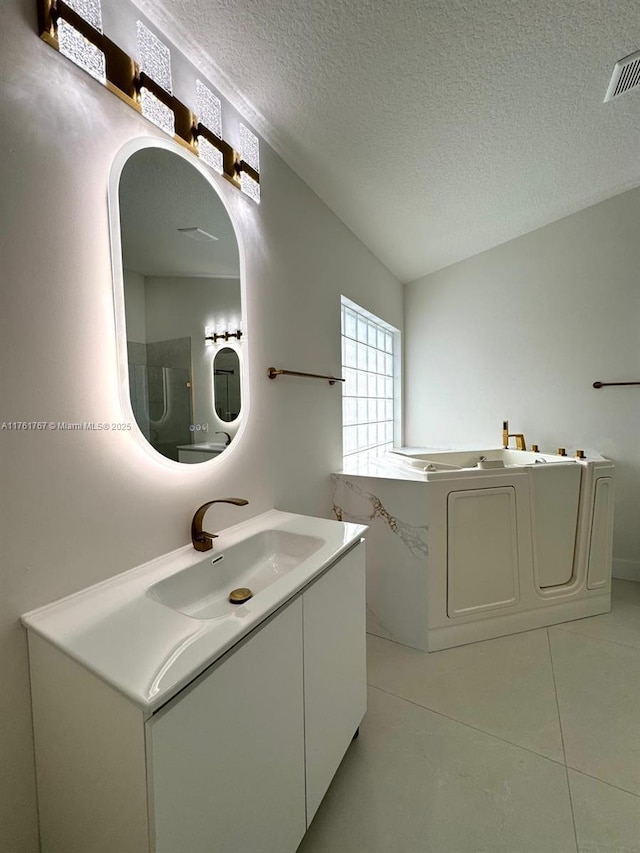 9785 San Luca St, Lake Worth, FL 33467 - bathroom with a textured ceiling, vanity, tile patterned floors, and washer / clothes dryer
