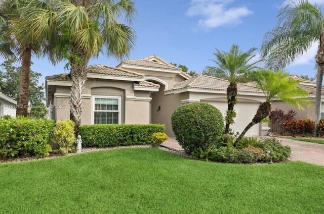 9785 San Luca St, Lake Worth, FL 33467 - mediterranean / spanish-style house with an attached garage, a tile roof, stucco siding, and a front lawn