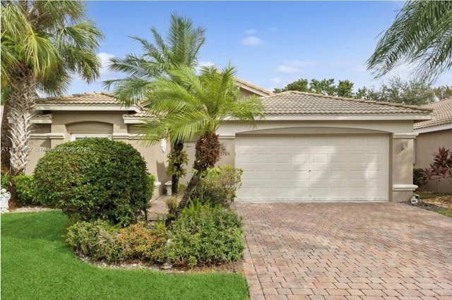 9785 San Luca St, Lake Worth, FL 33467 - mediterranean / spanish-style house featuring stucco siding, a tiled roof, and decorative driveway