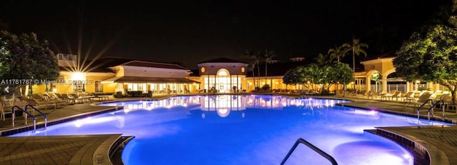 9785 San Luca St, Lake Worth, FL 33467 - pool at twilight featuring a patio area and a community pool