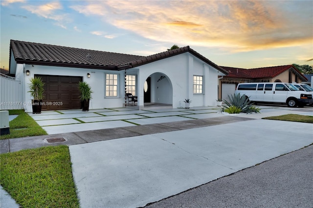 mediterranean / spanish-style house featuring stucco siding, driveway, and an attached garage