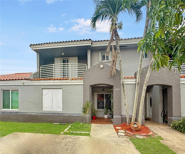 view of front of home featuring stucco siding and a balcony