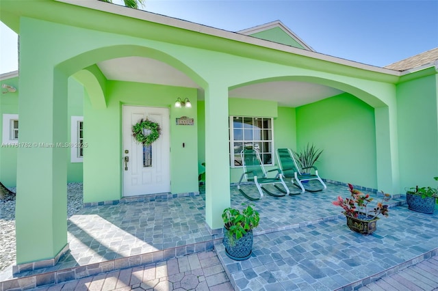 view of exterior entry featuring stucco siding