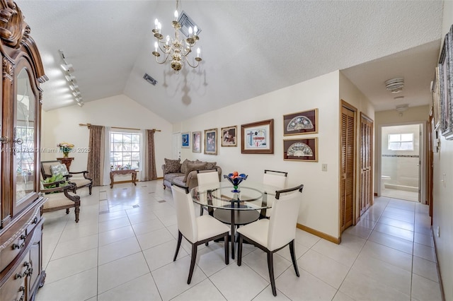 dining area featuring light tile patterned floors, a notable chandelier, vaulted ceiling, and a textured ceiling