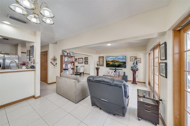 living room with light tile patterned flooring, baseboards, visible vents, and a textured ceiling