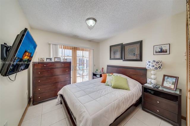 bedroom featuring light tile patterned flooring, a textured ceiling, and baseboards