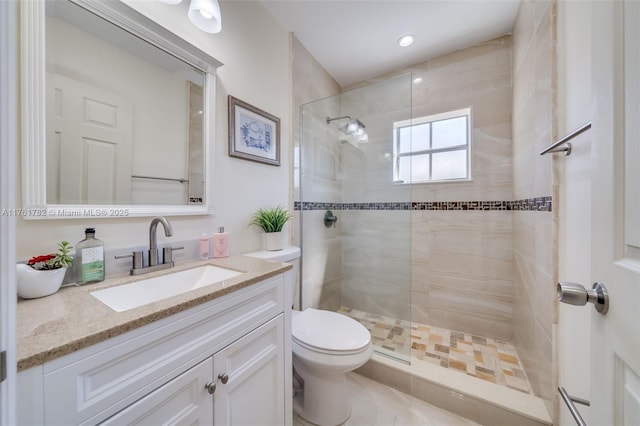 bathroom featuring toilet, a stall shower, and vanity