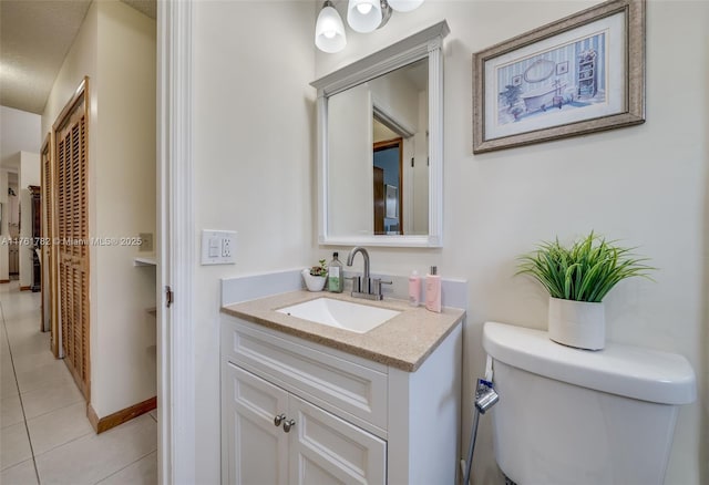 bathroom with toilet, tile patterned flooring, and vanity