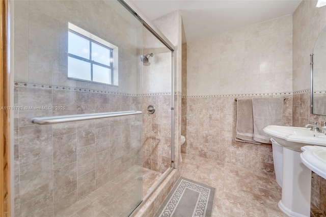 bathroom featuring toilet, tile walls, and a shower stall