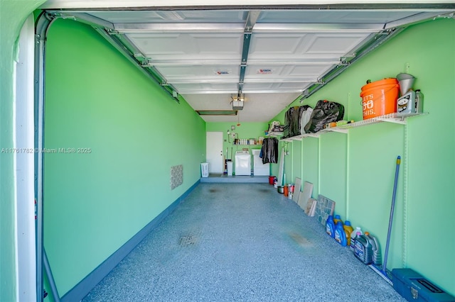 garage with washing machine and clothes dryer and a garage door opener