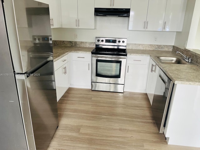 kitchen with under cabinet range hood, a sink, white cabinetry, stainless steel appliances, and light wood-style floors