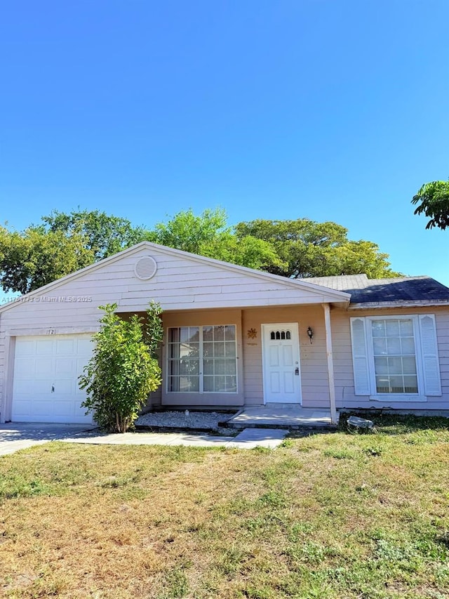 ranch-style home with an attached garage and a front lawn