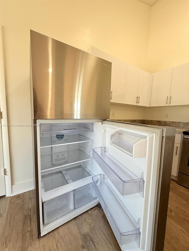 room details featuring white cabinetry, stove, and wood finished floors