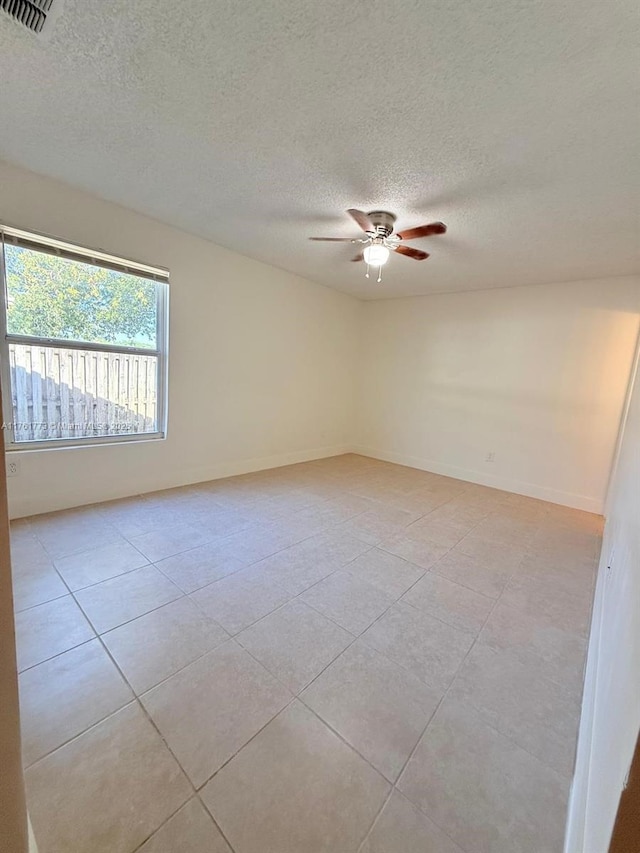 unfurnished room featuring visible vents, baseboards, light tile patterned floors, a textured ceiling, and a ceiling fan