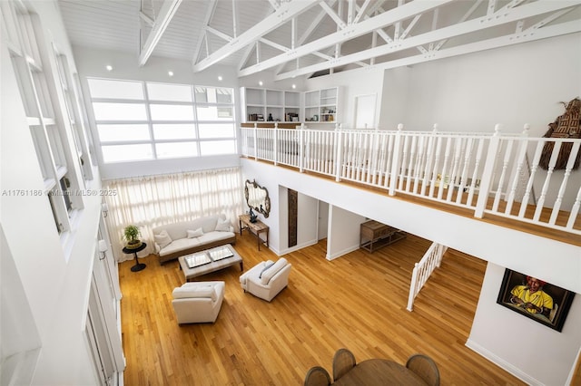 living area featuring wood finished floors and a towering ceiling