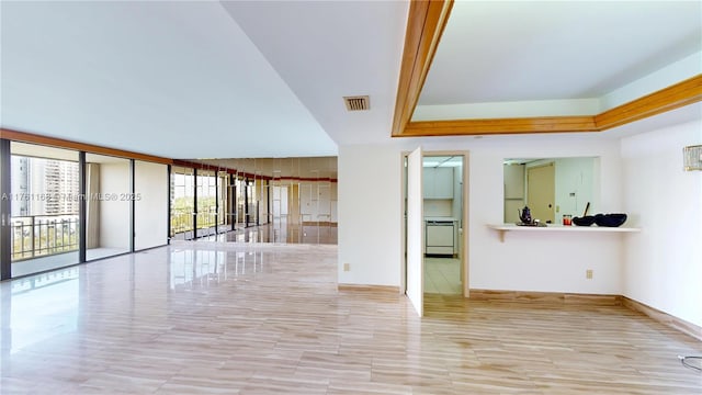 unfurnished living room featuring visible vents, a raised ceiling, and floor to ceiling windows