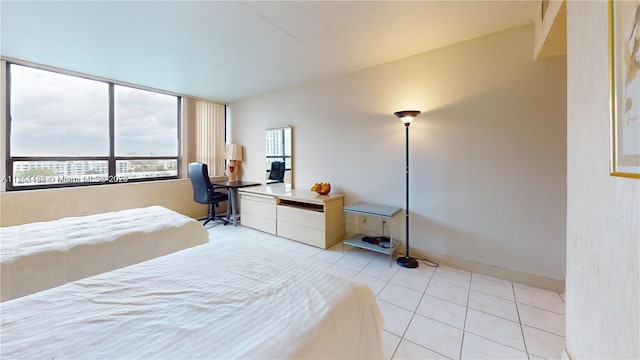 bedroom with light tile patterned floors, built in study area, and baseboards