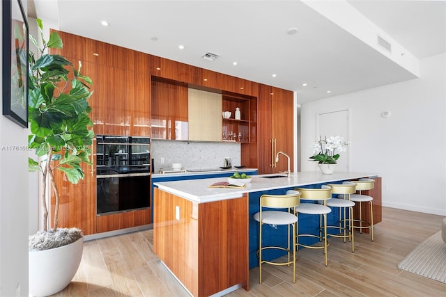 kitchen featuring backsplash, visible vents, a spacious island, and modern cabinets