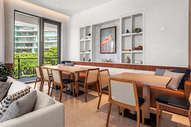 dining area with built in features, light speckled floor, and breakfast area