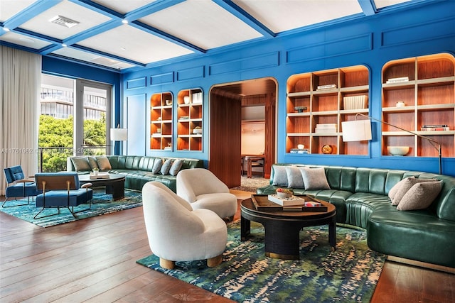 living room with visible vents, coffered ceiling, hardwood / wood-style floors, and a decorative wall