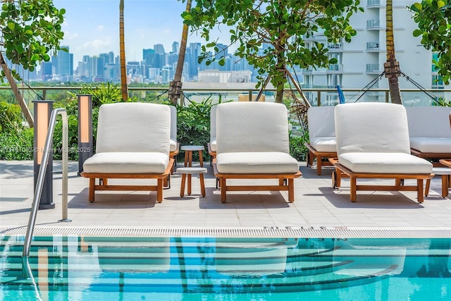 view of swimming pool with a patio and a city view