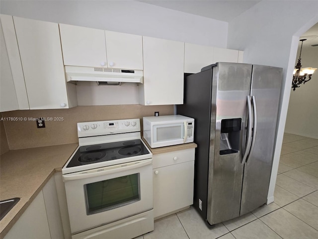 kitchen featuring under cabinet range hood, light countertops, light tile patterned floors, white cabinets, and white appliances