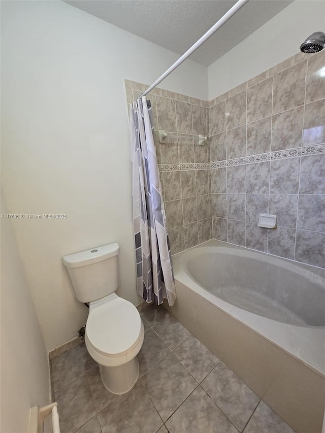 full bathroom featuring tile patterned floors, shower / tub combo with curtain, a textured ceiling, and toilet