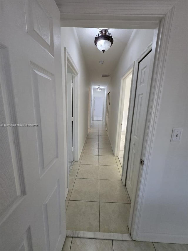 corridor featuring light tile patterned floors and visible vents