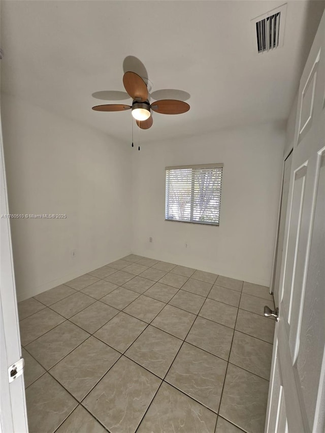 spare room with light tile patterned floors, a ceiling fan, and visible vents