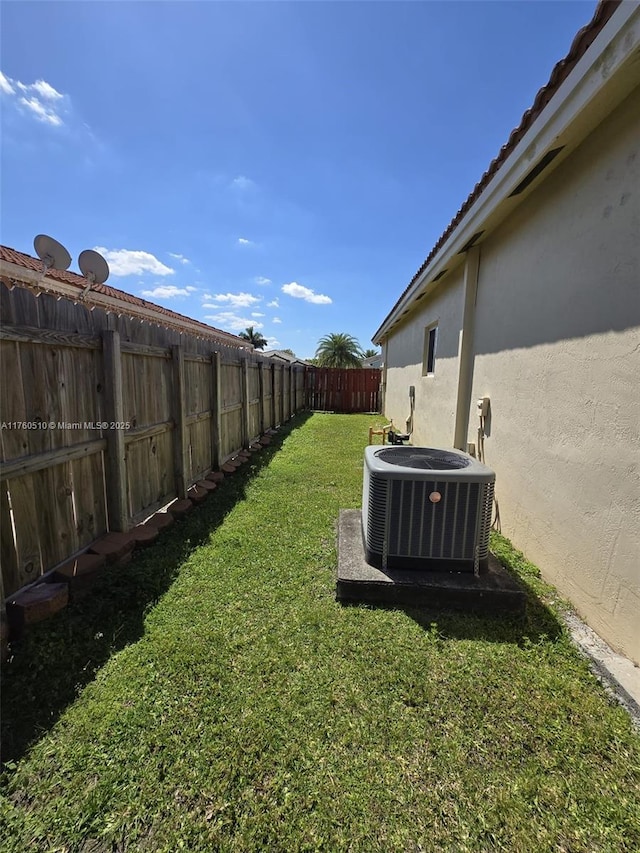 view of yard with central air condition unit and a fenced backyard