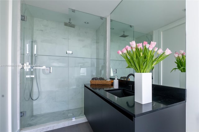 bathroom with double vanity, a stall shower, and a sink