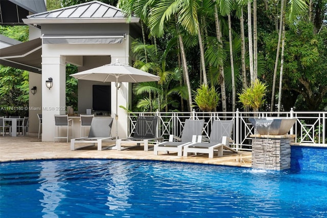 view of pool featuring a patio, a fenced in pool, fence, and outdoor dry bar