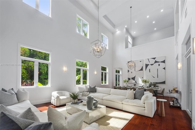 living area with recessed lighting, baseboards, a notable chandelier, and wood finished floors