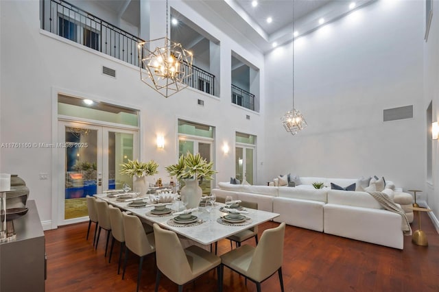 dining area featuring dark wood finished floors, visible vents, french doors, and an inviting chandelier