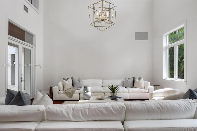 living room with a wealth of natural light, visible vents, and a high ceiling