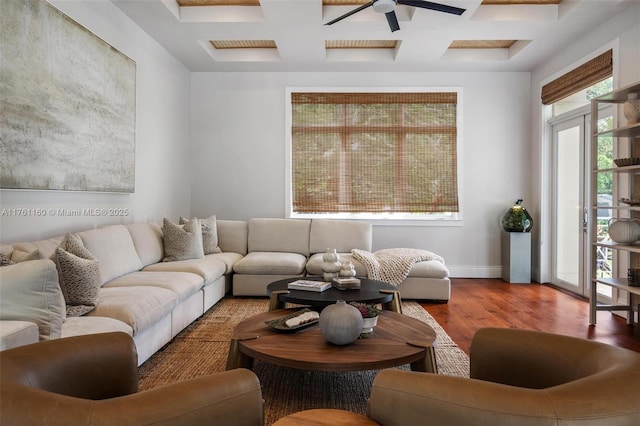 living area with beam ceiling, a ceiling fan, coffered ceiling, wood finished floors, and baseboards