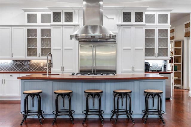 kitchen with a sink, white cabinets, appliances with stainless steel finishes, and butcher block countertops