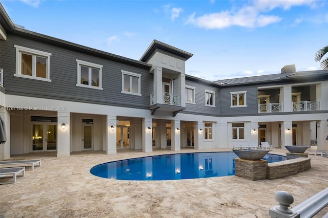 view of pool with french doors, a patio, and a pool with connected hot tub