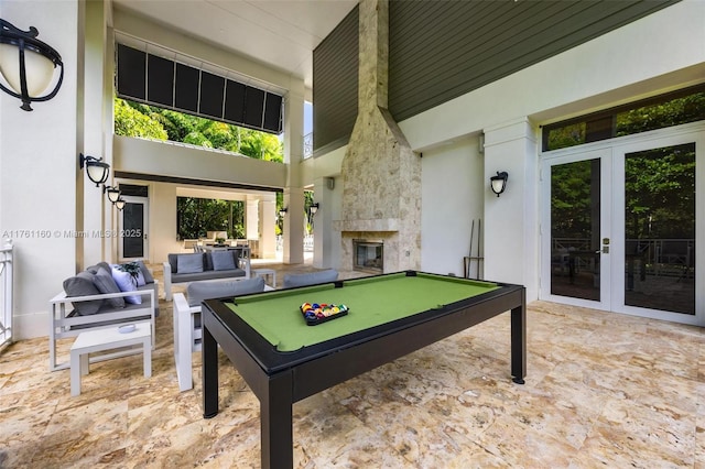 rec room featuring french doors, pool table, and a fireplace