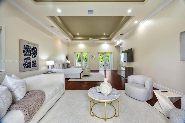 bedroom featuring wood finished floors, visible vents, baseboards, recessed lighting, and a raised ceiling