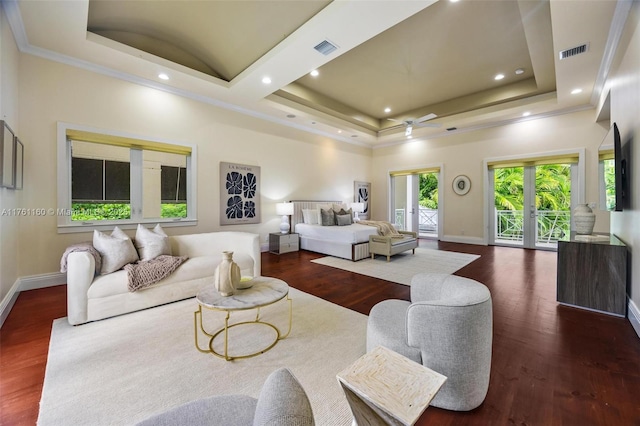 bedroom with a raised ceiling, wood finished floors, access to exterior, and visible vents