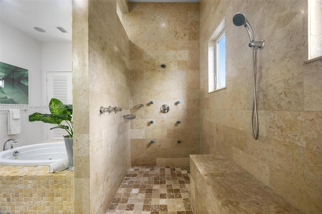 bathroom with a tub with jets, visible vents, and tiled shower