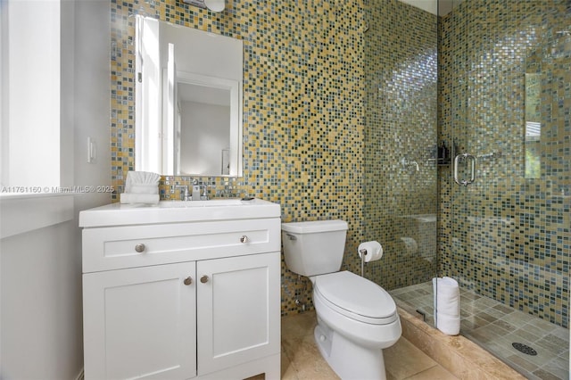 bathroom featuring toilet, tile walls, a stall shower, and vanity