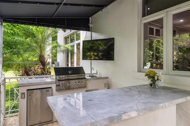 view of patio / terrace featuring a sink, a grill, and an outdoor kitchen