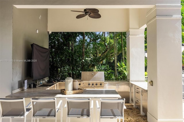 view of patio / terrace featuring area for grilling, an outdoor kitchen, and a ceiling fan