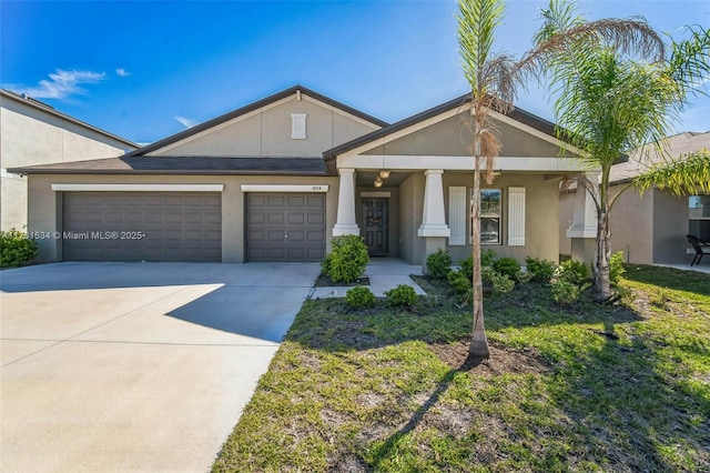 view of front of property with an attached garage, driveway, and stucco siding