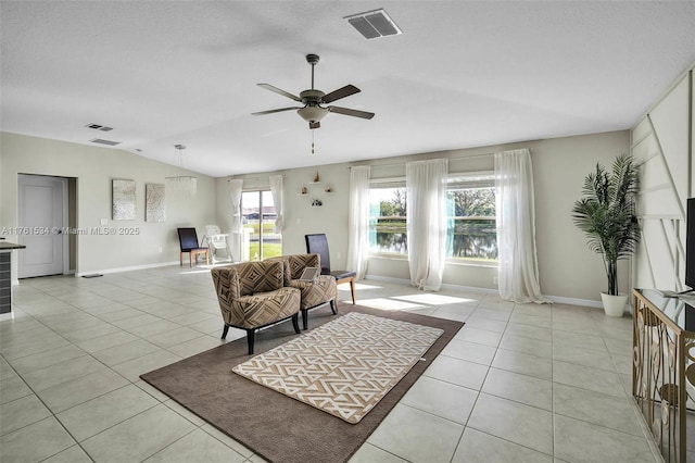 living area featuring light tile patterned floors, visible vents, and vaulted ceiling