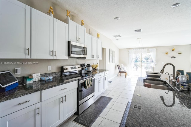 kitchen featuring a sink, stainless steel appliances, visible vents, and light tile patterned flooring