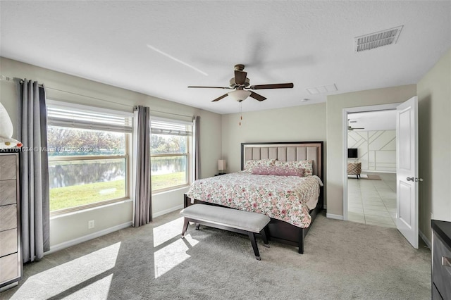 carpeted bedroom featuring a ceiling fan, visible vents, and baseboards