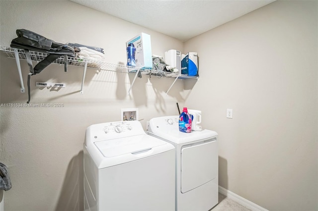 laundry area with laundry area, separate washer and dryer, and baseboards